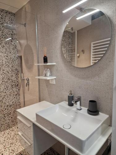 a bathroom with a white sink and a mirror at Cozy flat mins walk to Navigli and metro Porta Genova in Milan