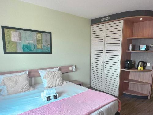 a bedroom with a bed and a book shelf at 5 minutes du Parc de la Villette - Charmant studio in Pantin