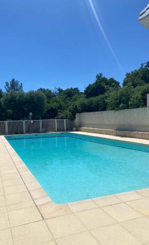 une grande piscine avec de l'eau bleue dans l'établissement T2 40m2 Rez-de-Jardin, bord de mer, Cavalaire-sur-Mer, à Cavalaire-sur-Mer