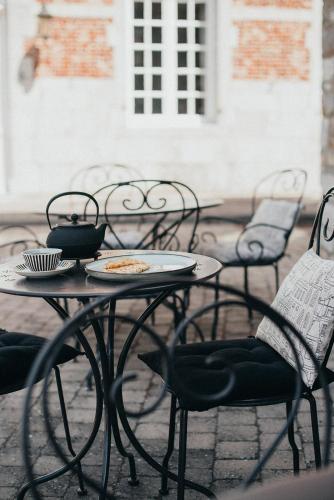 a table and chairs with a plate of food on it at La Maison des Dames in La Sauvenière