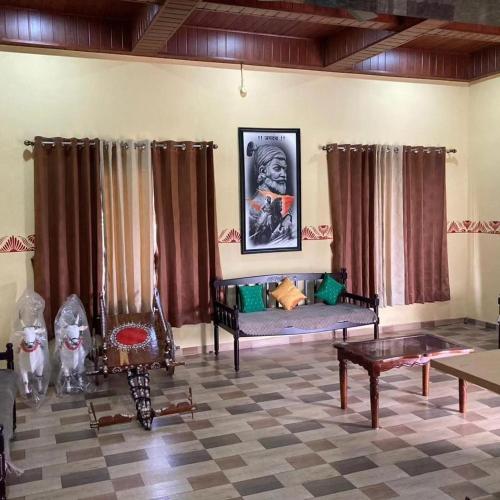 a living room with a couch and a table at Aabancha Wada By Joy Suites in Junnar