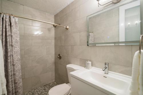 a bathroom with a toilet and a sink and a mirror at Ocean Blue Beach Apt in Luquillo