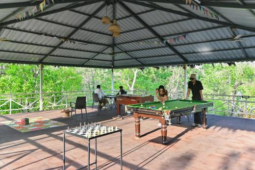 a man and a dog playing pool in a tent at Saj In The Forest, Pench National Park in Seonī