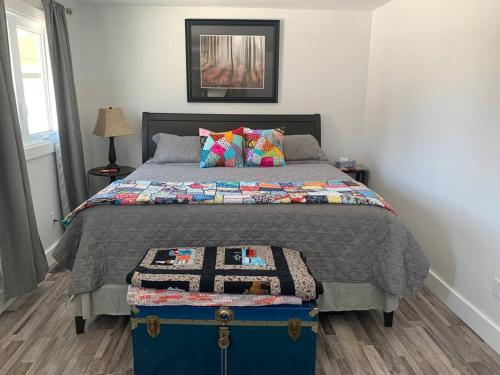 a bedroom with a bed with a blue trunk at Hatchet Harbour Vacation Home in Herring Neck