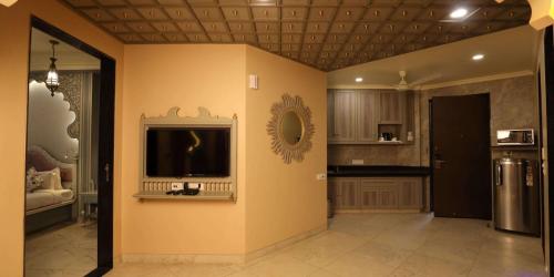 a living room with a tv on a wall at Neonz Resort & Club in Anand