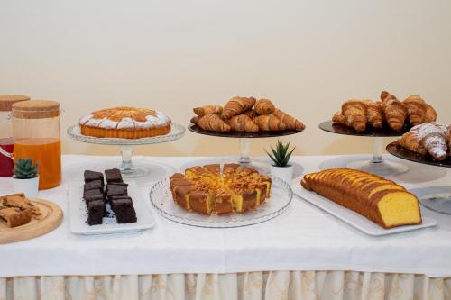 un tavolo con molti tipi diversi di torte e pasticcini di Hotel Rondinella e Viola a Rimini