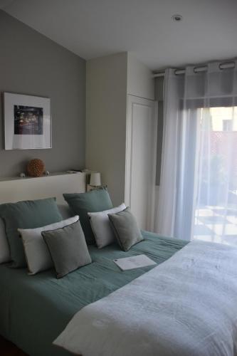 a bedroom with a large bed with pillows and a window at LES CHAMBRES DE MARIE in Bordeaux