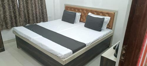a bed with black and white sheets and pillows at Sneh bandhan banquet & lawn in Kaliānpur