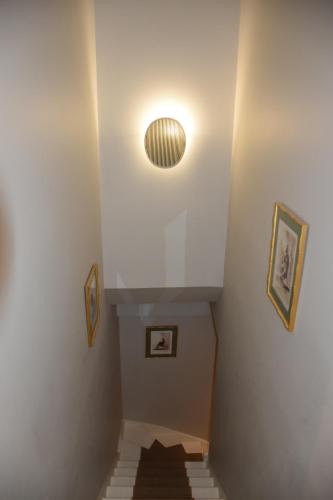a stairway with a light on the ceiling and a stair case at LES CHAMBRES DE MARIE in Bordeaux