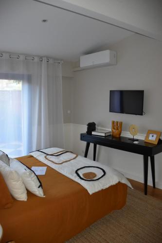 1 dormitorio con 1 cama y TV en la pared en LES CHAMBRES DE MARIE, en Burdeos
