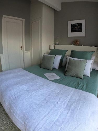 a bedroom with a large bed with pillows at LES CHAMBRES DE MARIE in Bordeaux