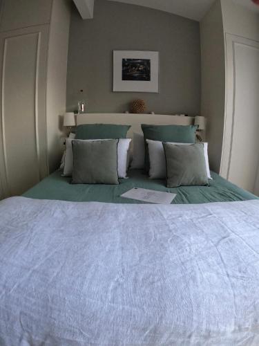 a bedroom with a large bed with white sheets and pillows at LES CHAMBRES DE MARIE in Bordeaux
