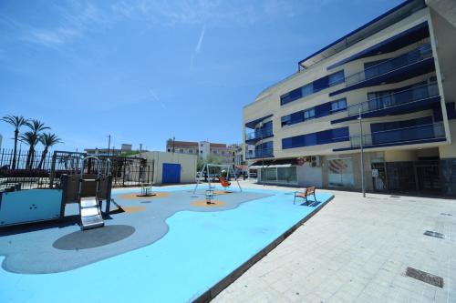 una piscina vacía con parque infantil frente a un edificio en Dos Bahías Orangecosta, en Peñíscola