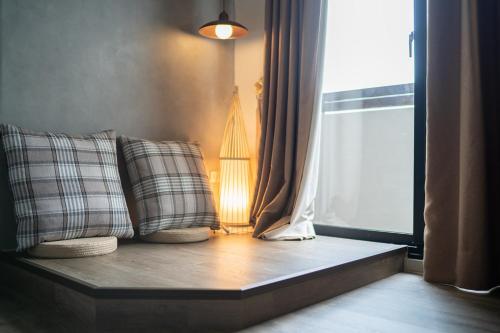 a window seat with two pillows in front of a window at Jinyou B&B in Chishang