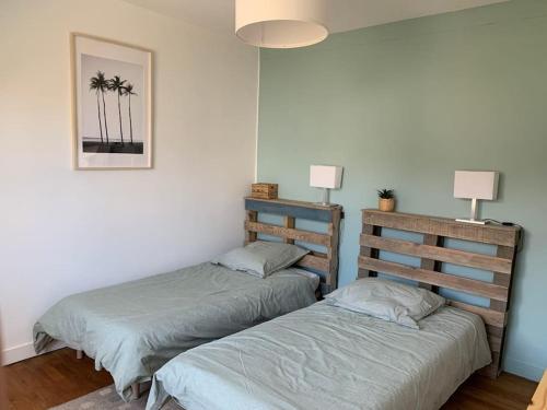 deux lits jumeaux dans une chambre avec deux lampes dans l'établissement Ty Reuz - Maison vue mer à Morgat, à Crozon