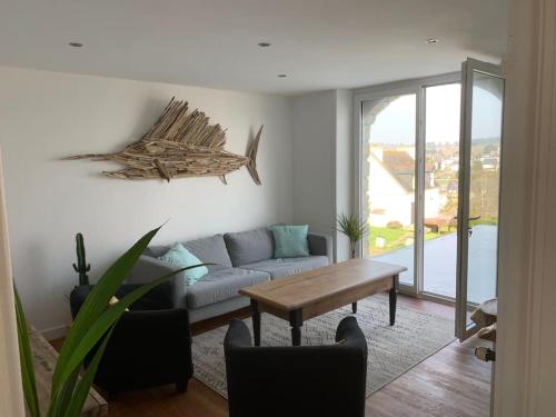 un salon avec un canapé et une table dans l'établissement Ty Reuz - Maison vue mer à Morgat, à Crozon