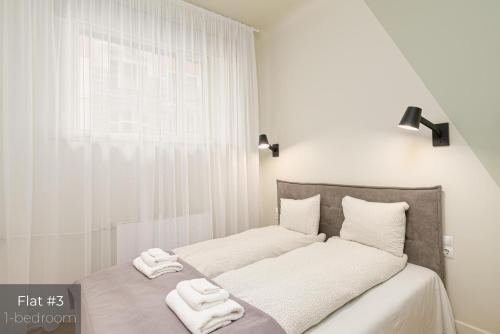 a bedroom with a bed with two towels on it at Dandelion Apartments Stabu in Rīga