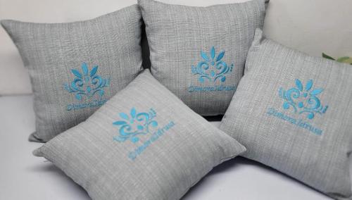 un grupo de cuatro almohadas con un logo azul en ellas en Dimora Idrusa, en Otranto