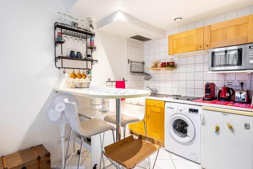une cuisine avec une table et une machine à laver dans l'établissement GuestReady - Studio Confortable au centre de Paris, à Paris