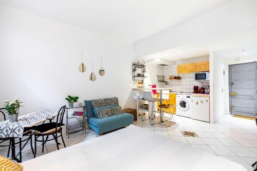 un salon avec un canapé bleu et une cuisine dans l'établissement GuestReady - Studio Confortable au centre de Paris, à Paris