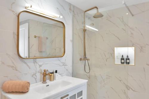 ein weißes Badezimmer mit Waschbecken und Spiegel in der Unterkunft Elegante dúplex con increíbles vistas al mar Mijas - CASCADA DE RIVIERA C2 in Sitio de Calahonda