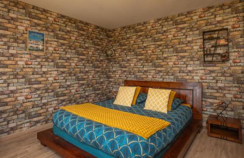 um quarto com uma cama numa parede de tijolos em Studio 1 ATELIER VINCI em Amboise