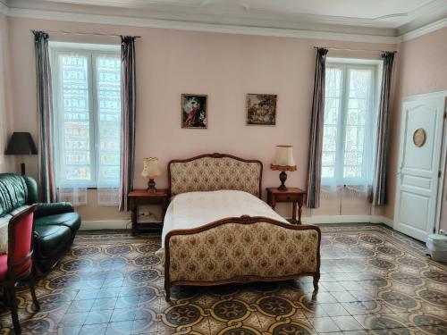 - une chambre avec un lit, un canapé et des fenêtres dans l'établissement Les Volets Bleus, à Sallèles-dʼAude