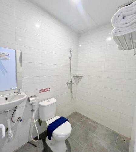 a bathroom with a toilet and a sink and a shower at Lexus Hotel Medan in Medan