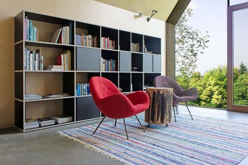 two chairs and a book shelf with books at Urlaub in Designer-Ferienwohnung, die zusätzlich mit traditionellem Weinkeller und hochwertiger Einrichtung überzeugt in Sausal