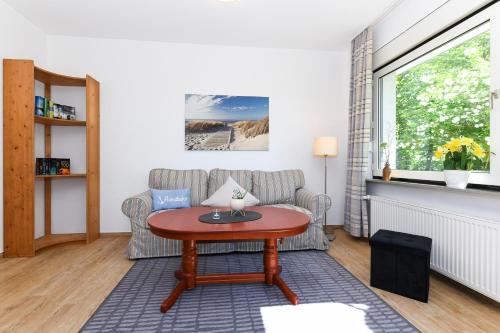 uma sala de estar com um sofá e uma mesa em Ferienwohnung AnneHuus em Bensersiel