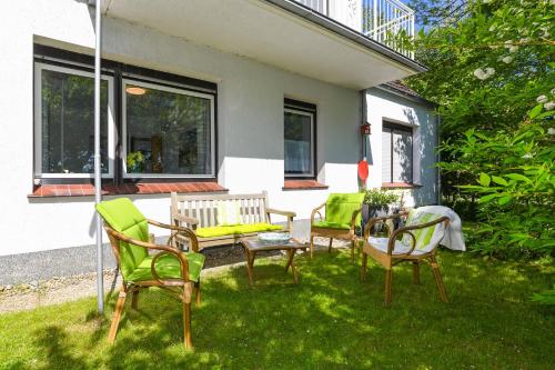 um grupo de cadeiras e uma mesa num quintal em Ferienwohnung AnneHuus em Bensersiel