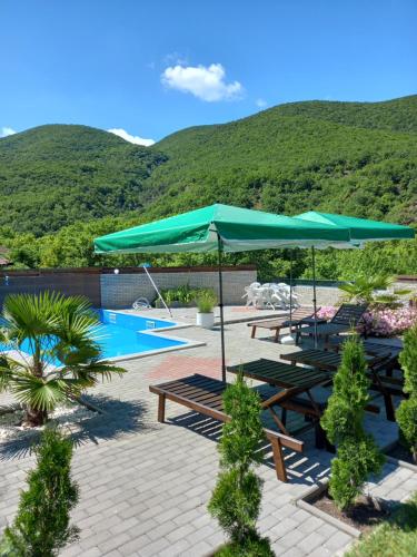 une terrasse avec des tables et des parasols ainsi qu'une piscine dans l'établissement Vila Nikola, 