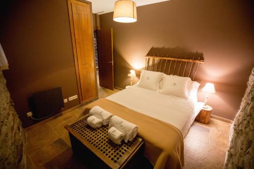 a bedroom with a bed with towels on a table at R de Rural - Casa Rural de les Arnes in Encamp