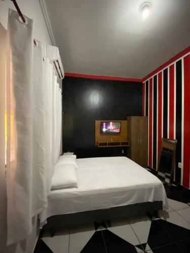 カロリナにあるAconchego Ramosのベッドルーム(白いベッド1台、テレビ付)