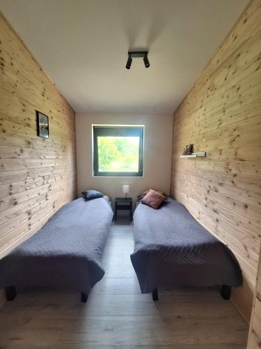 two twin beds in a room with a window at W dolinie Rocha in Krasnobród