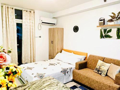 a living room with a bed and a couch at Pamz Studio Condo Unit in Lapu Lapu City