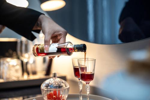 a person pouring a glass of red wine at Portugal Boutique Hotel in Lisbon