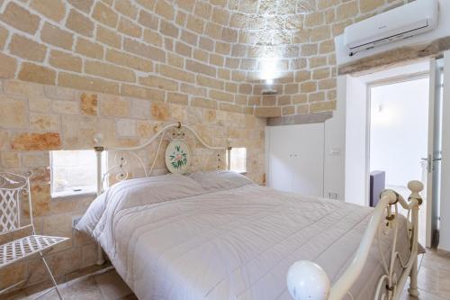 a bedroom with a large bed in a stone wall at Trulli San Pietro in Putignano