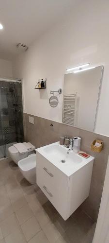 a bathroom with a sink and a toilet and a mirror at BARBARA Classy Apartments 103, Wellness in Siracusa