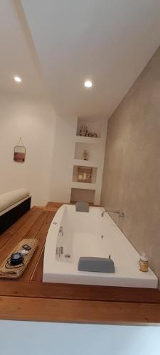 a large bath tub in a room with wooden floors at BARBARA Classy Apartments 103, Wellness in Siracusa