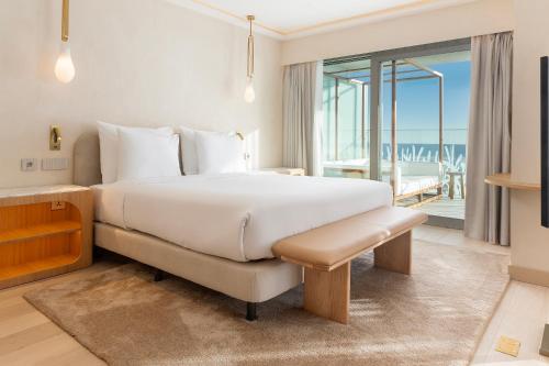 a bedroom with a large bed and a balcony at EVOLUTION Cascais-Estoril Hotel in Estoril