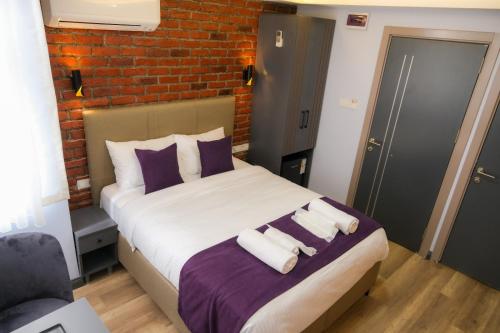 a bedroom with a bed with purple and white pillows at mansion yellow hotel in Istanbul