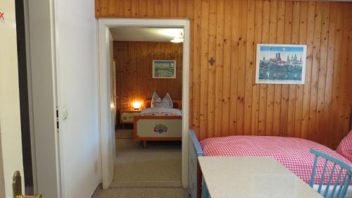 a room with a bedroom with a bed in it at Gästehaus Huber - traditional Sixties Hostel in Feichten
