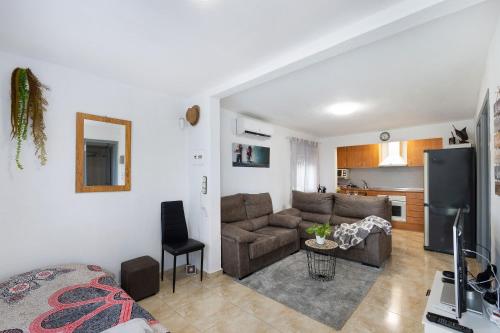 a living room with a couch and a kitchen at Cal Jaume in Masquefa
