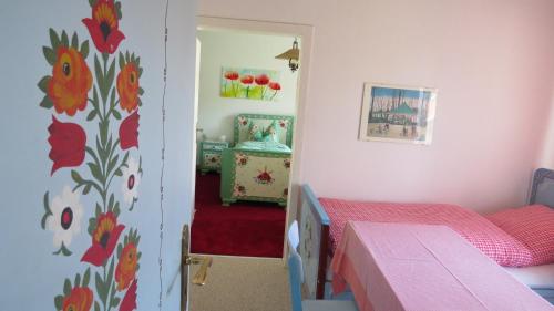 a bedroom with a bed and a door with a room with a table at Gästehaus Huber - traditional Sixties Hostel in Feichten