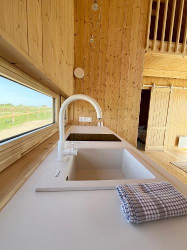 eine Küche mit Spüle in einem Raum mit Fenster in der Unterkunft Slowcabin in Retowo