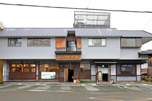 un grand bâtiment blanc avec une rue en face dans l'établissement Travel Inn Yoshitomi - Vacation STAY 37633v, à Taketa