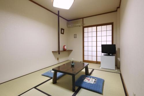 - un salon avec une table et une télévision dans l'établissement Travel Inn Yoshitomi - Vacation STAY 37633v, à Taketa