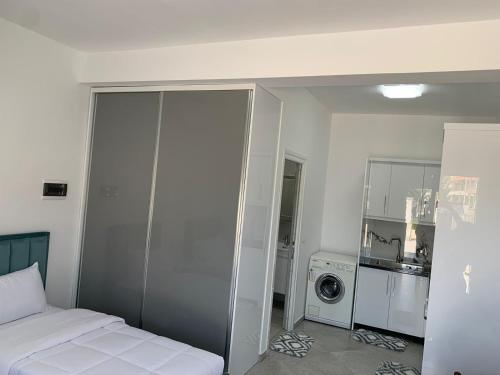 um quarto branco com uma cama e uma máquina de lavar roupa em Villa LIKAJ em Berati