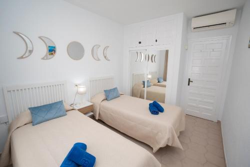 a bedroom with two beds with blue pillows at PINOS 22 MENYBER in Nerja